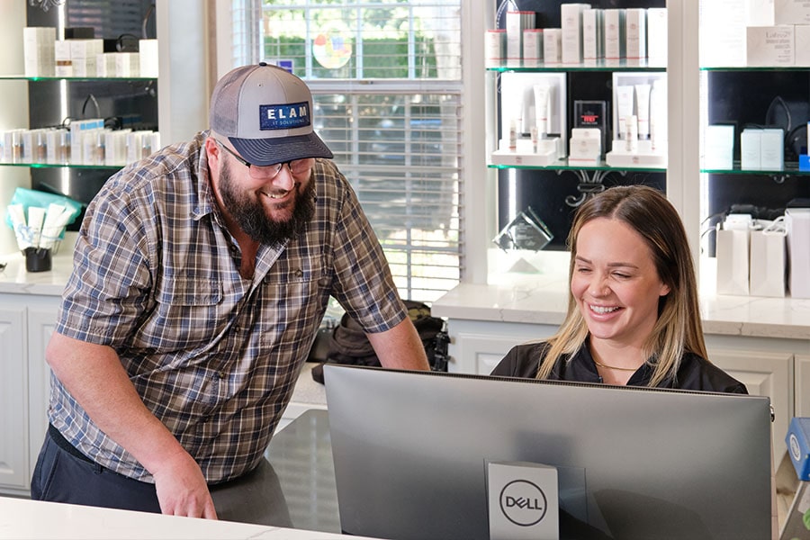 JD Elam assisting a client at their computer